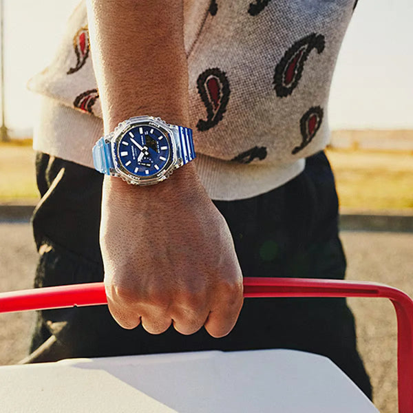 G-shock Referencia: ga-2100hc-2adrGenero: Hombre Composición: analogo, digital, cronometro, temporizador, alarma, calendario. Materiales: resina Color: Azul Impermeabilidad: 20 atm  Cristal: mineral Producto con garantía de 1 año en funcionamiento . Recomendaciones Reloj con resistencia al agua para sumergirse. No manipular los botones cuando se esté en contacto con el agua.