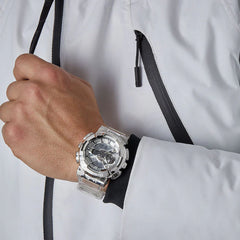 G-shock Referencia: gm-110scm-1adrGenero: hombre Composición: digital, analogo, cronometro, temporizador, alarma, calendario. Materiales: acero inoxidable y resina Color: transparente camuflado Impermeabilidad: 20 atm Cristal: mineral Producto con garantía de 1 año en funcionamiento . Recomendaciones Reloj con resistencia al agua para sumergirse. No manipular los botones cuando se esté en contacto con el agua